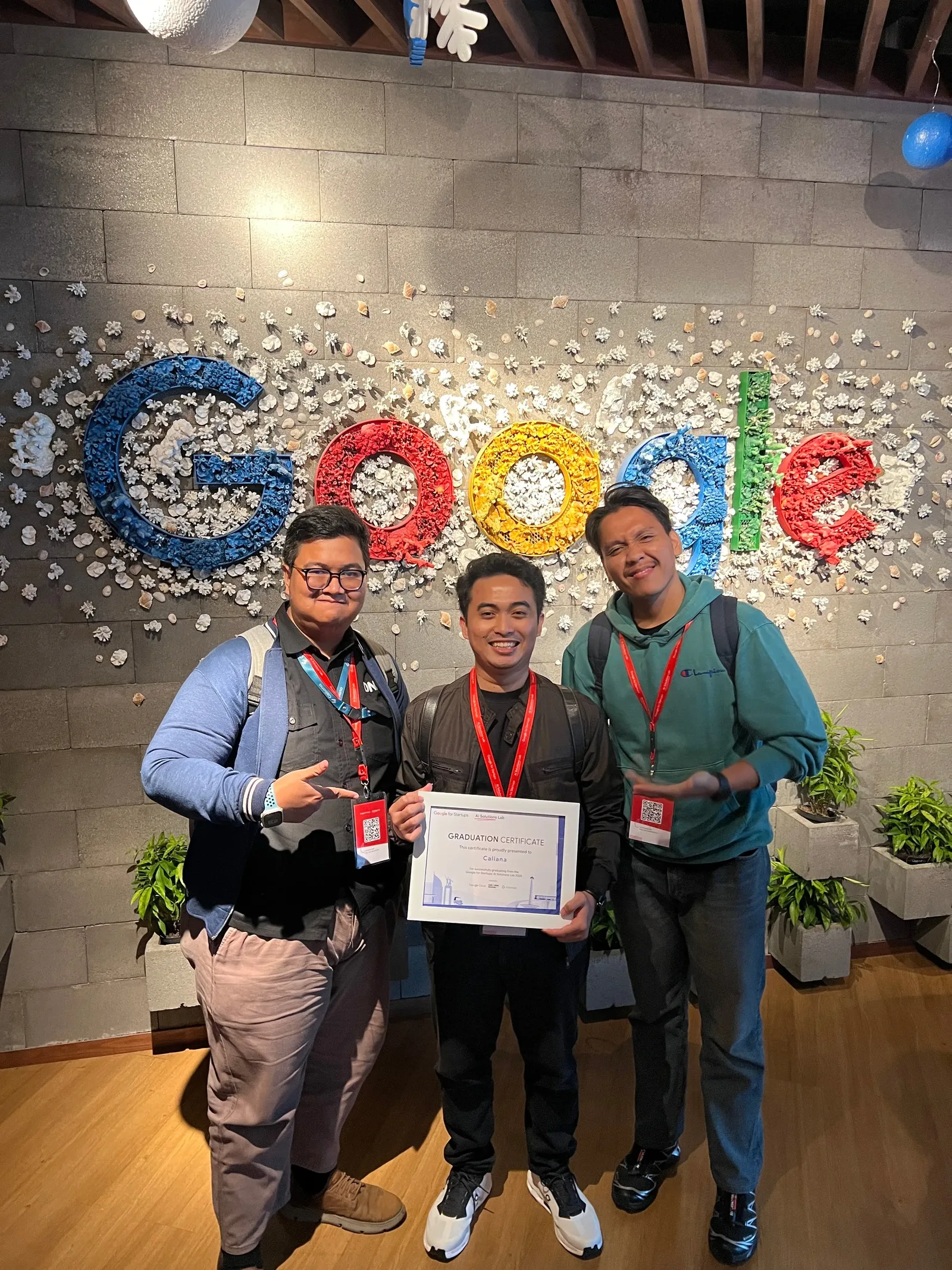 The Google for Startups graduation certificate, issued to Caliana, held in front of the Google logo wall